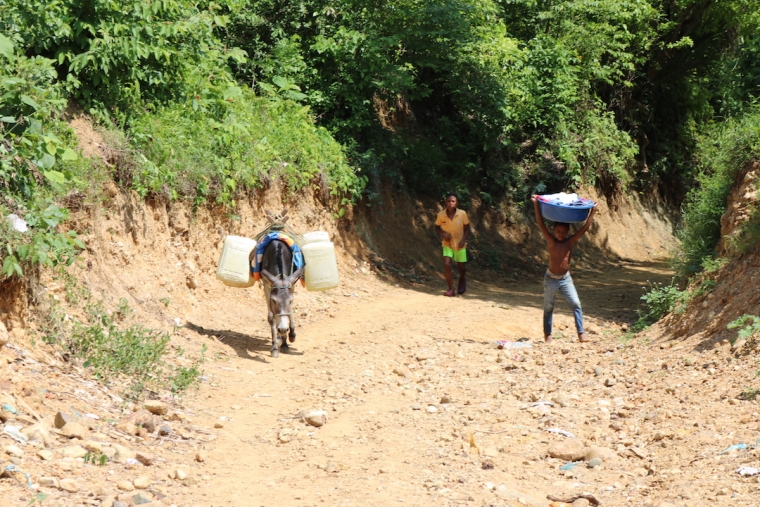 Niños y adultos deben caminar pueblo abajo para recolectar agua y lavar la ropa. El líquido es transportado por burros. Foto: Samuel López.