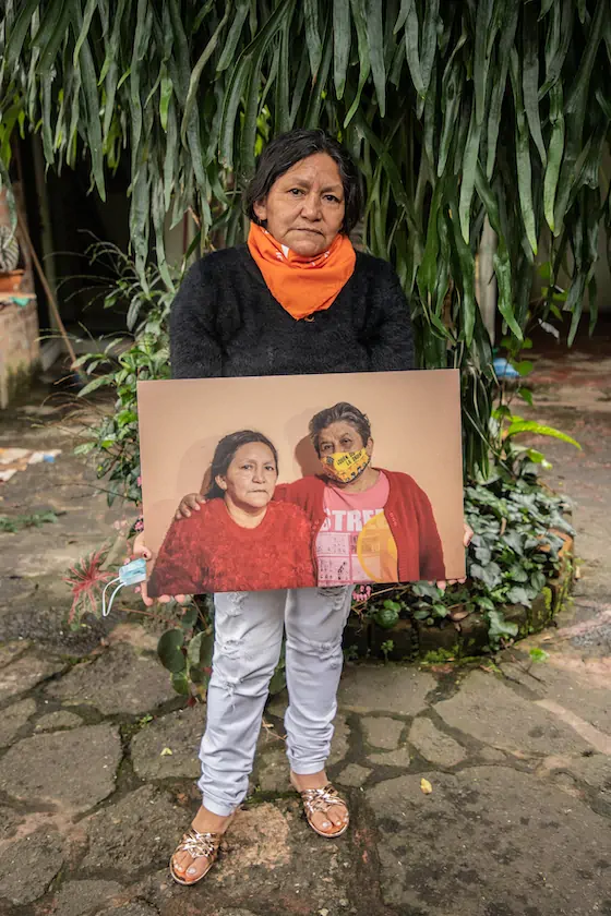 Luz Nelsy Rivera sostiene un retrato que le hicieron con su amiga y compañera de lucha, Ana Socorro Valencia. Ana Socorro y Luz Nelsy se unieron al Movice medio año después de la entrega de los restos de sus hijos. Foto: Sara Tejada Chávez.